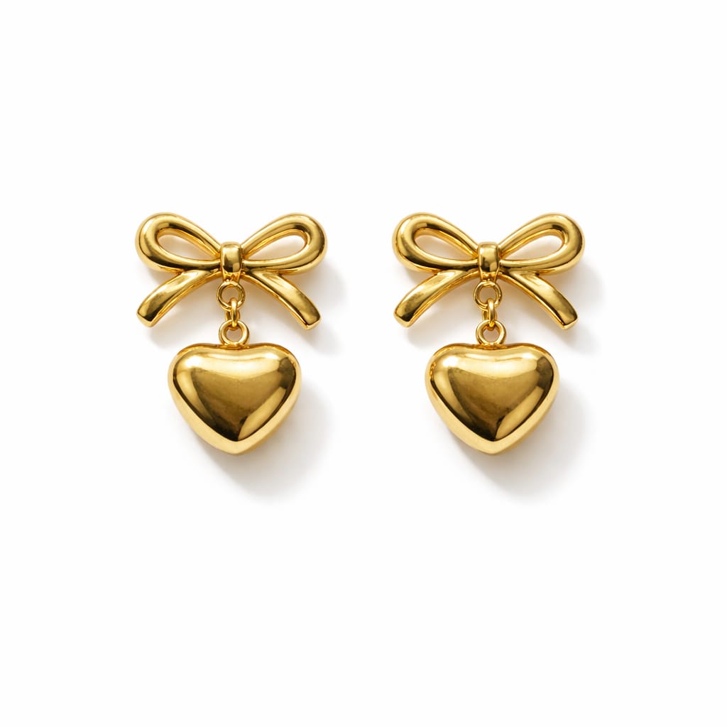 Gold bow and heart earrings on a white background